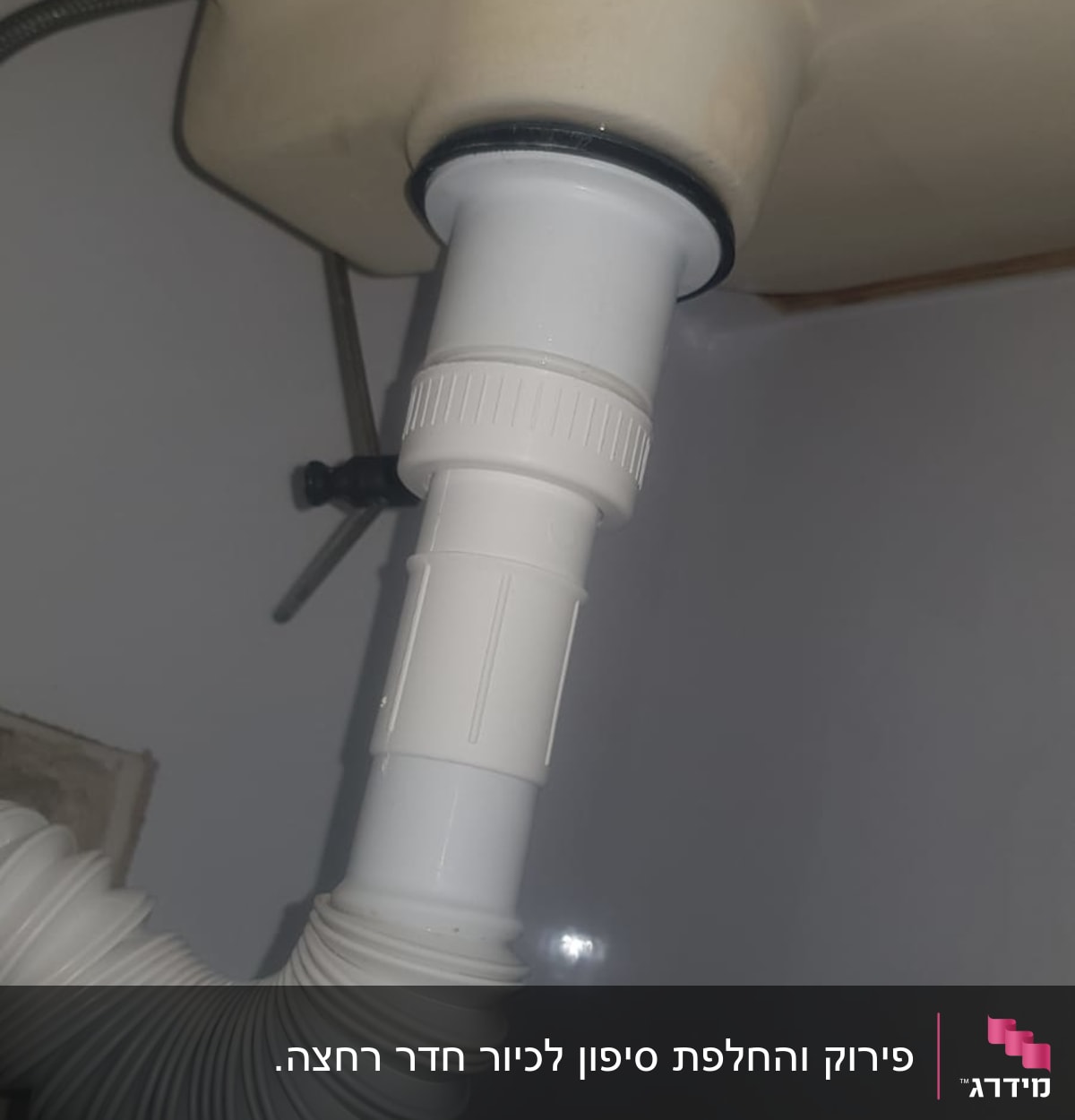 צינור פלסטיק לבן מתחת לכיור עם חיבור גמיש